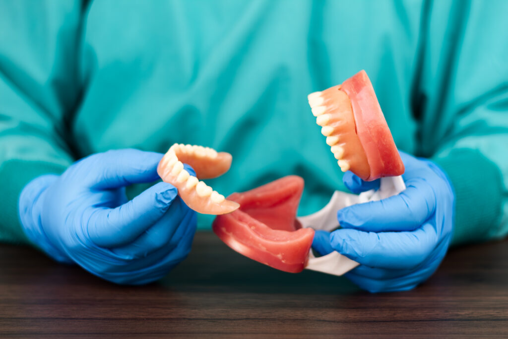 Dentist holding jaw model during full mouth reconstruction consultation
